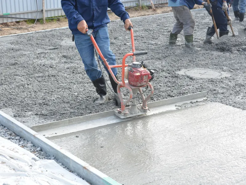 Worker pouring concrete on site