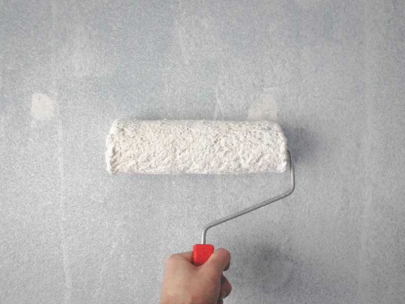 Painter rolling paint on a wall