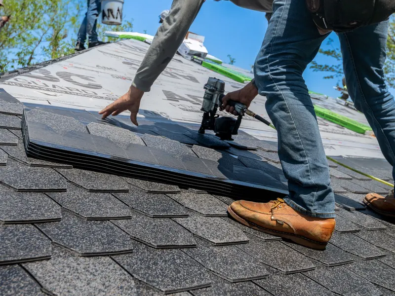 Roofer installing shingles on a roof