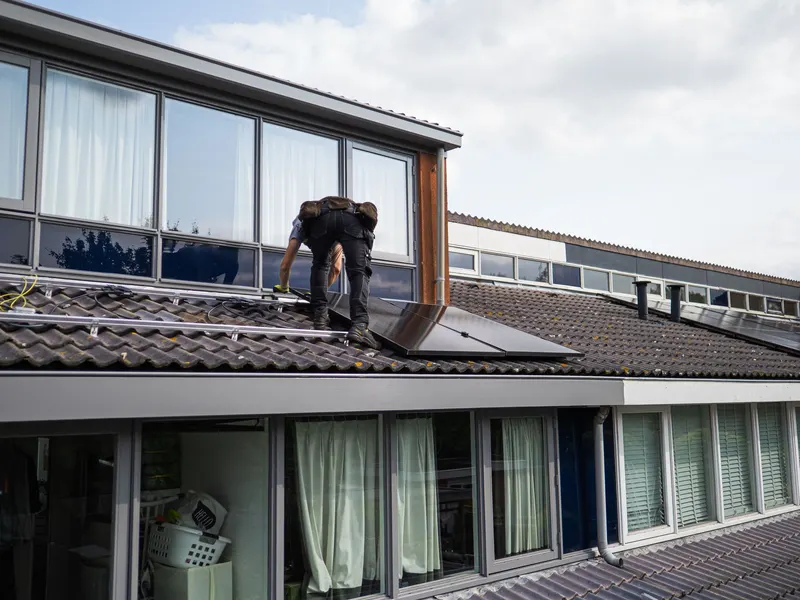 Workers installing rooftop solar panels